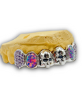 Gold grill with colorful gemstones on a white background